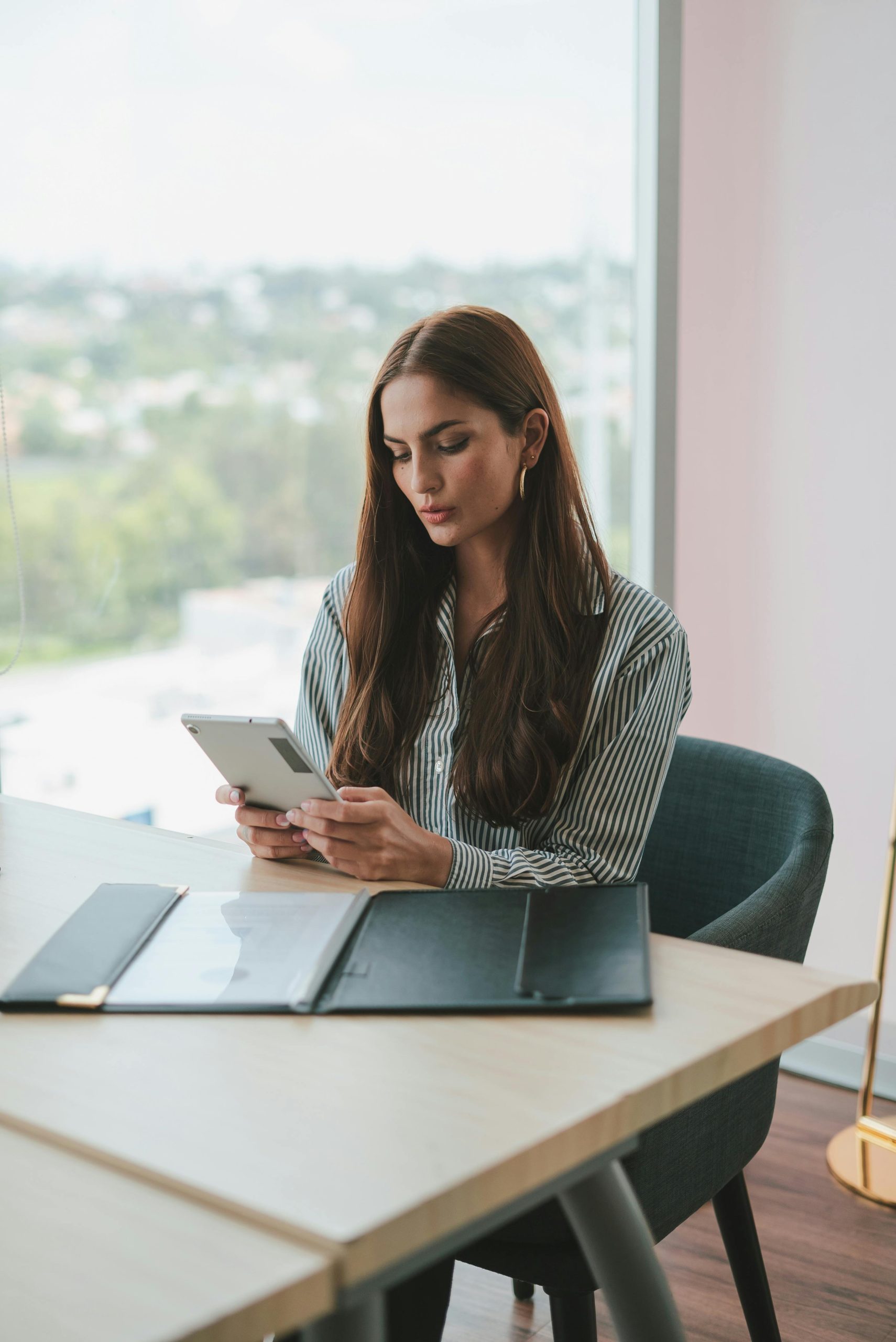 Businesswoman using tablet at desk in a contemporary office setting, Mexico City.